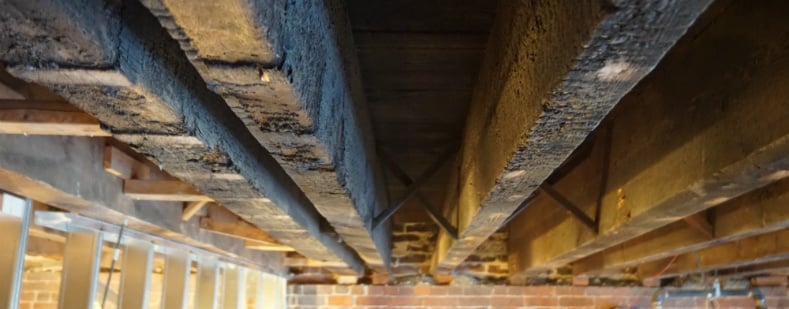 Smoke-damaged timber beams — before